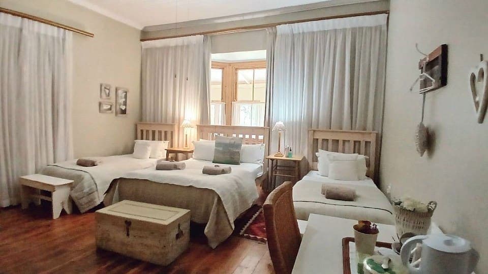 Calamus: the double bed and its two single beds, with the curtains drawn across the window