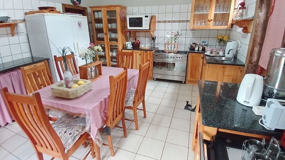 The communal self-catering kitchen, with a table laid for guests and a gas stove along the wall