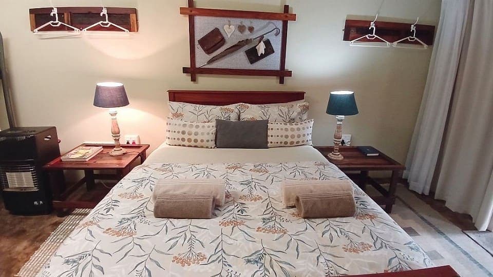 Frankincense: the double bed with its botanical print cover and two blue bedside lamps