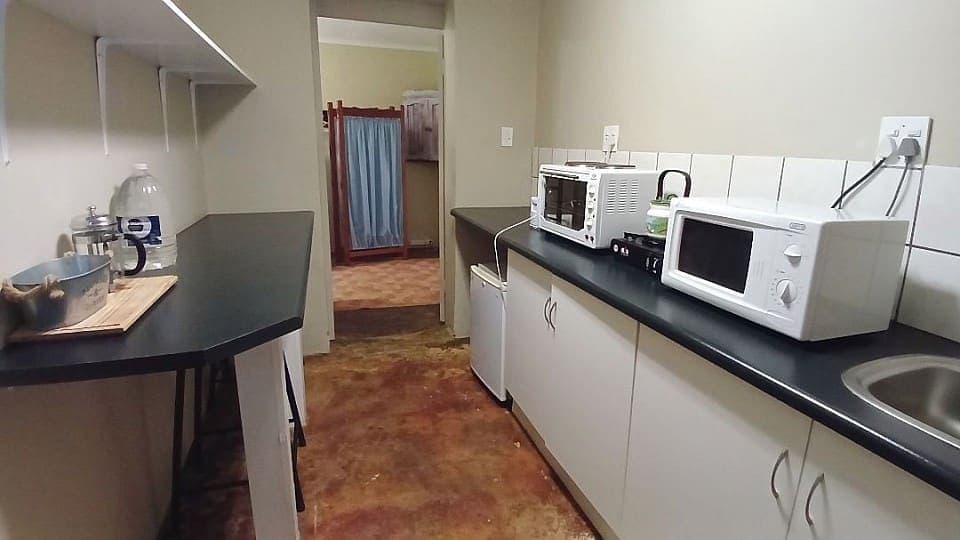 Frankincense: the room's own kitchen, with a microwave, kettle, sink and bar stools at the counter