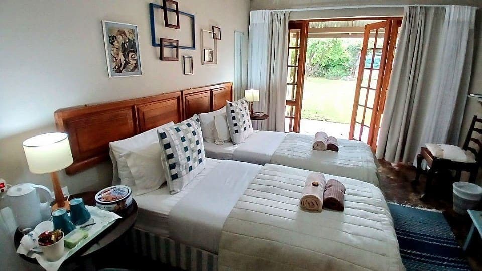 Myrrh: the beds with blue-and-white checked cushions, with the garden doors open behind them