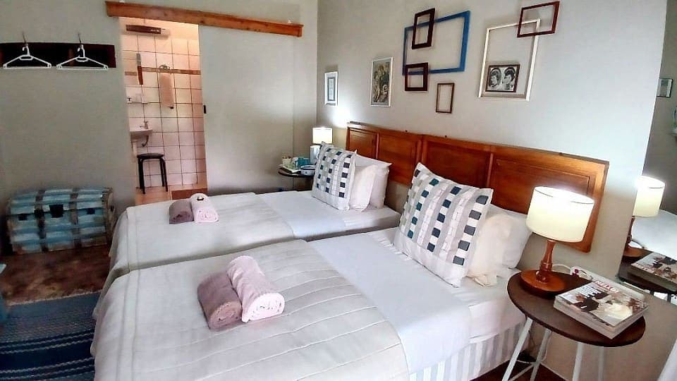 Myrrh: the beds with the door of the en-suite bathroom standing open
