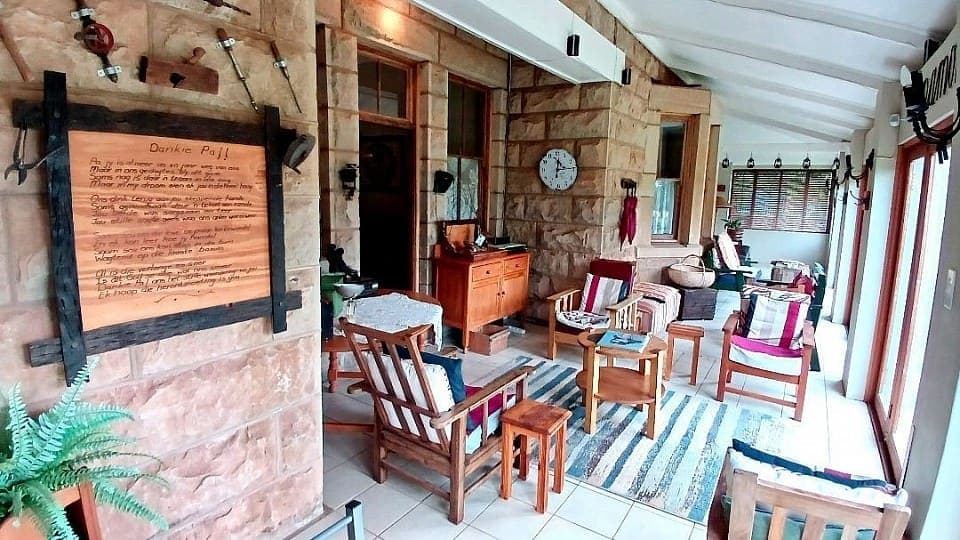 The patio facing the entrance, with the hand-painted welcome board on the stone wall