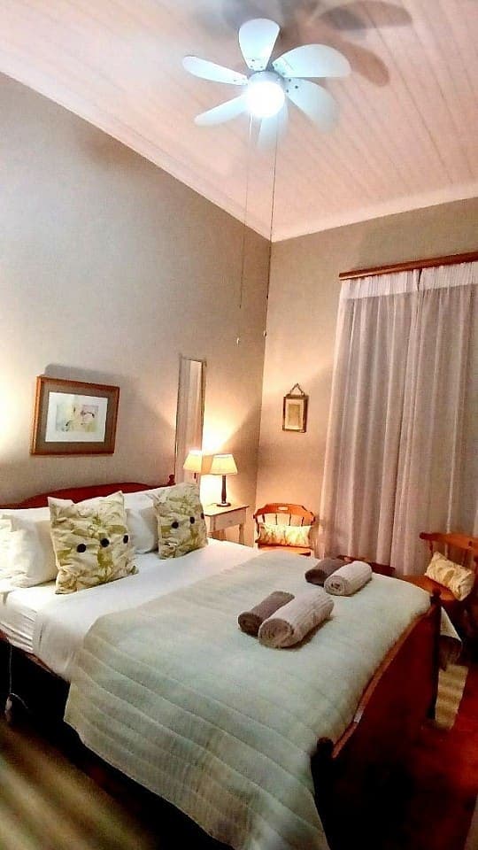 Spikenard: the double bed under the ceiling fan, with the curtained window to the right